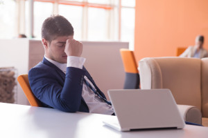 frustrated young business man working on laptop computer at office